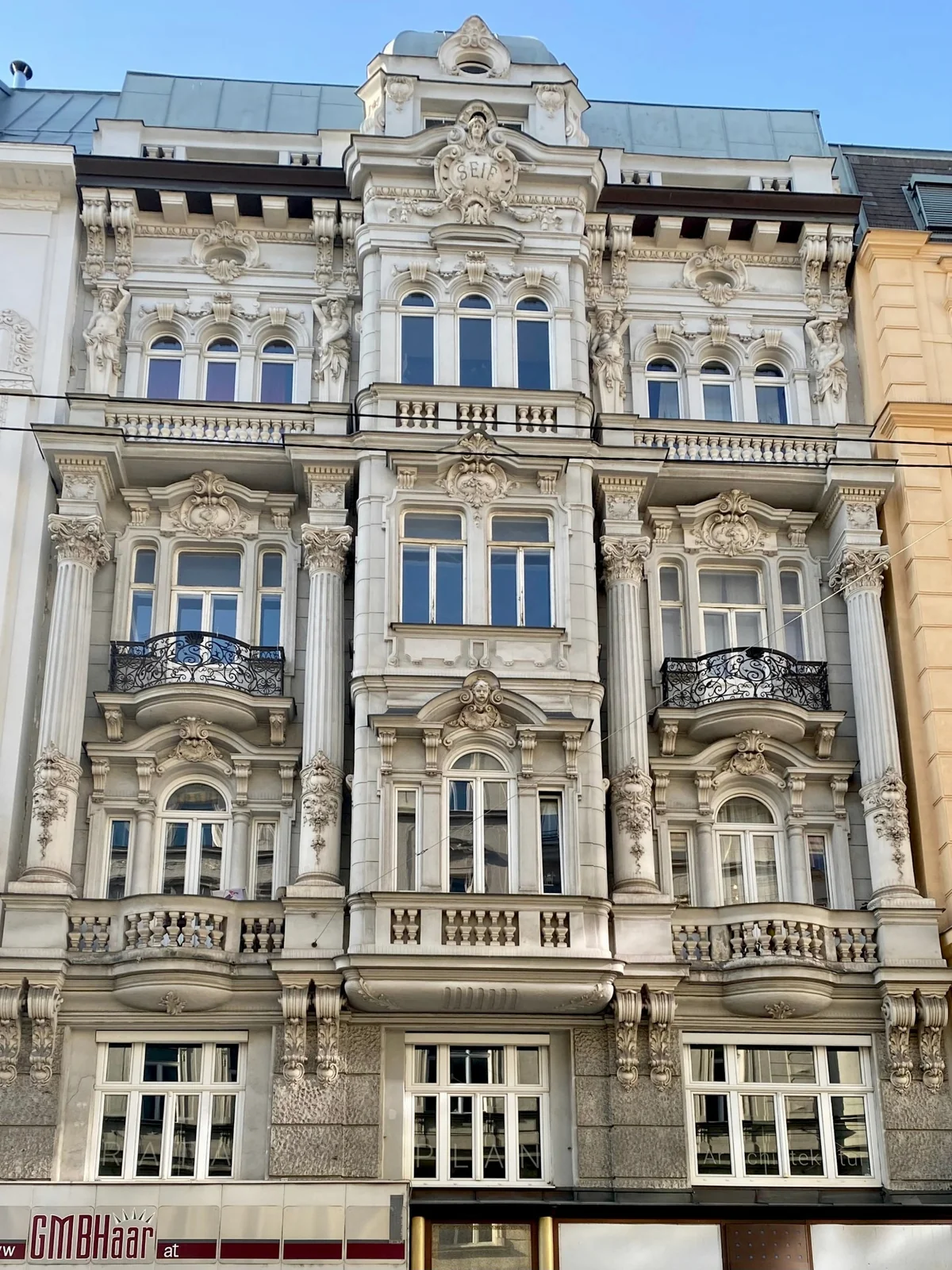 Historische Altbaufassade mit Stuckverzierungen, hohen Fenstern und schmiedeeisernen Balkonen