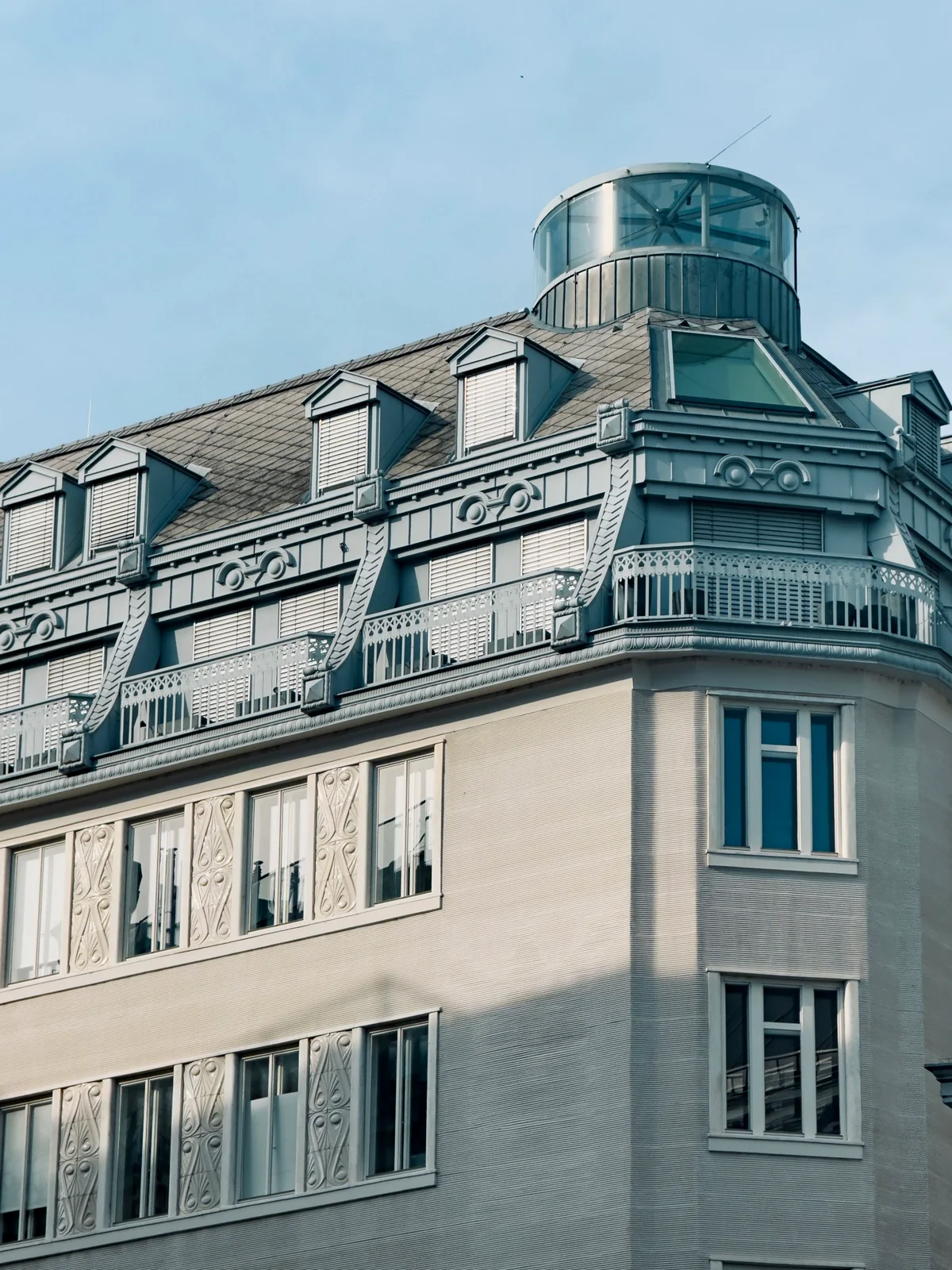 Dachkonstruktion eines Wiener Altbaus mit Gauben und rundem gläsernem Dachaufbau